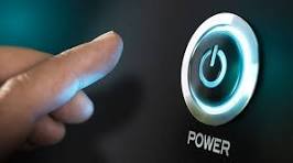 A close-up image of a hand pressing a glowing power button on a device.