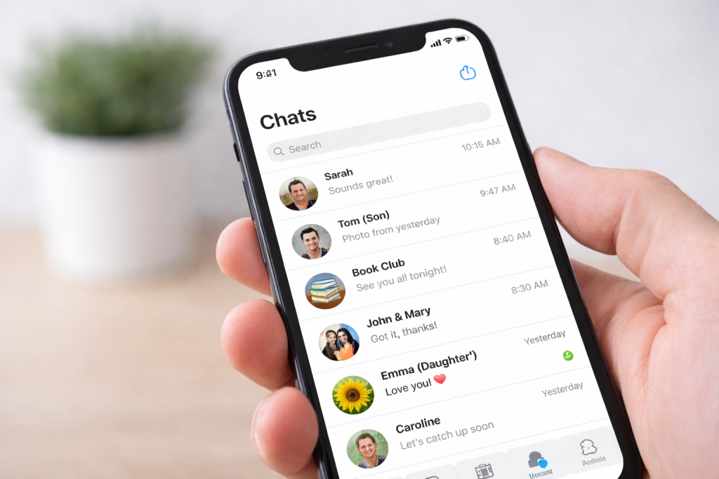 A smartphone showing a list of WhatsApp conversations on the screen.